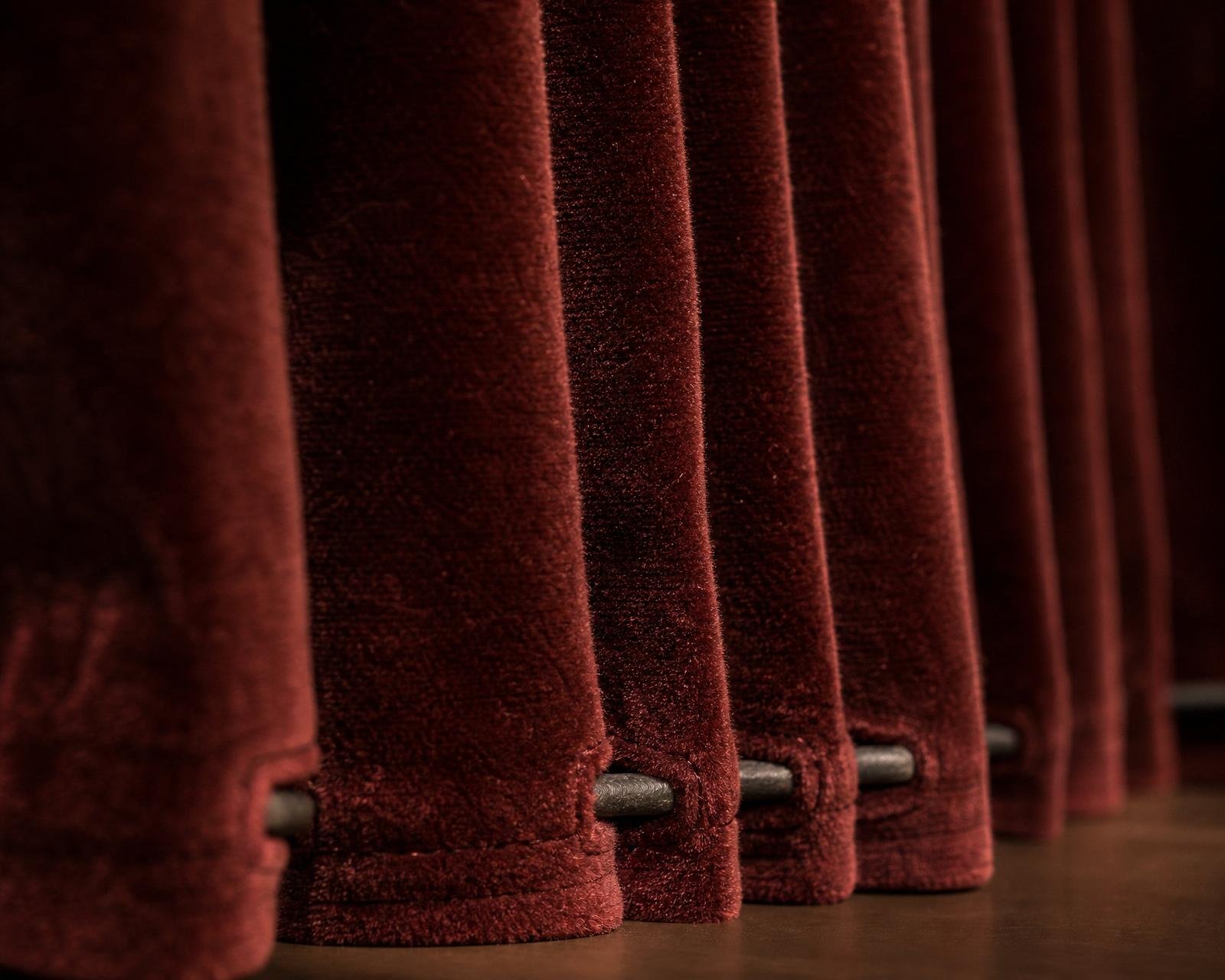 Macro close-up of hand-pleated burgundy velvet curtain hem