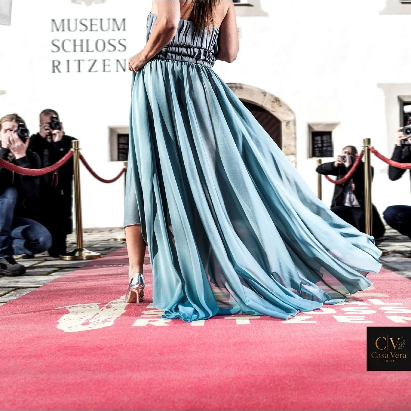 Printed pink event mat laid as an arrival floor at a museum reception with a guest walking across it